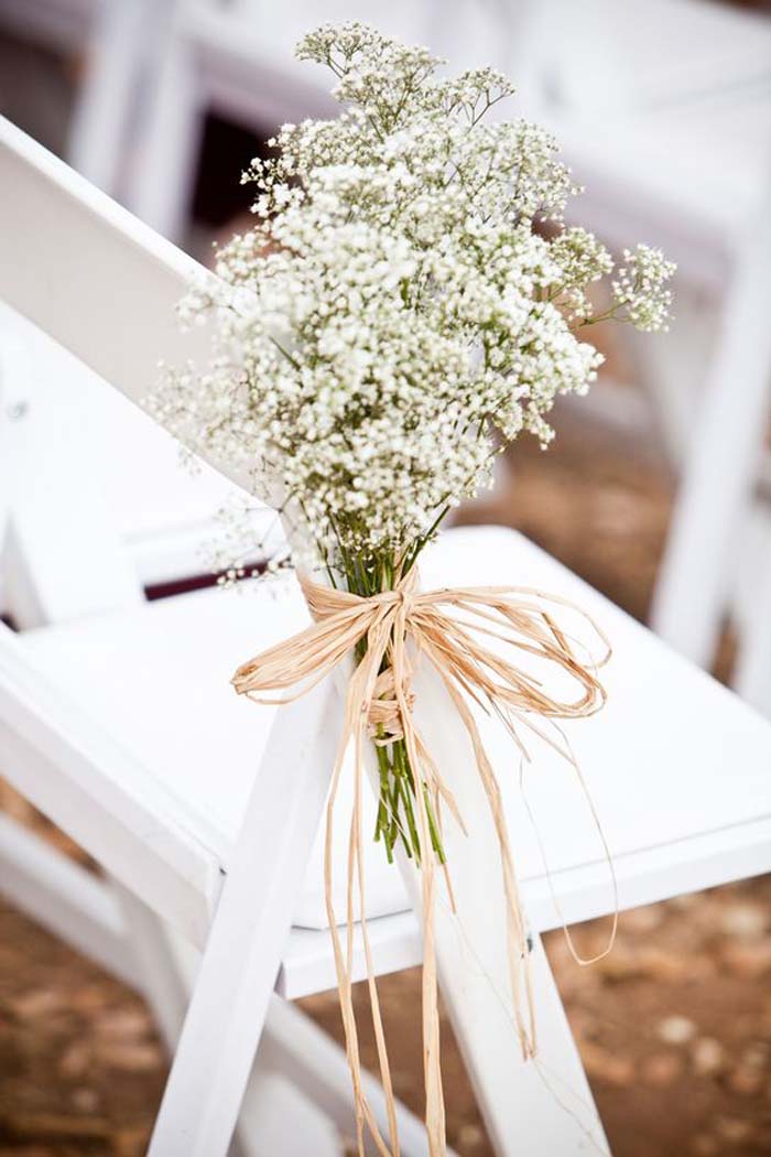 flowers on chairs to style wedding aisle